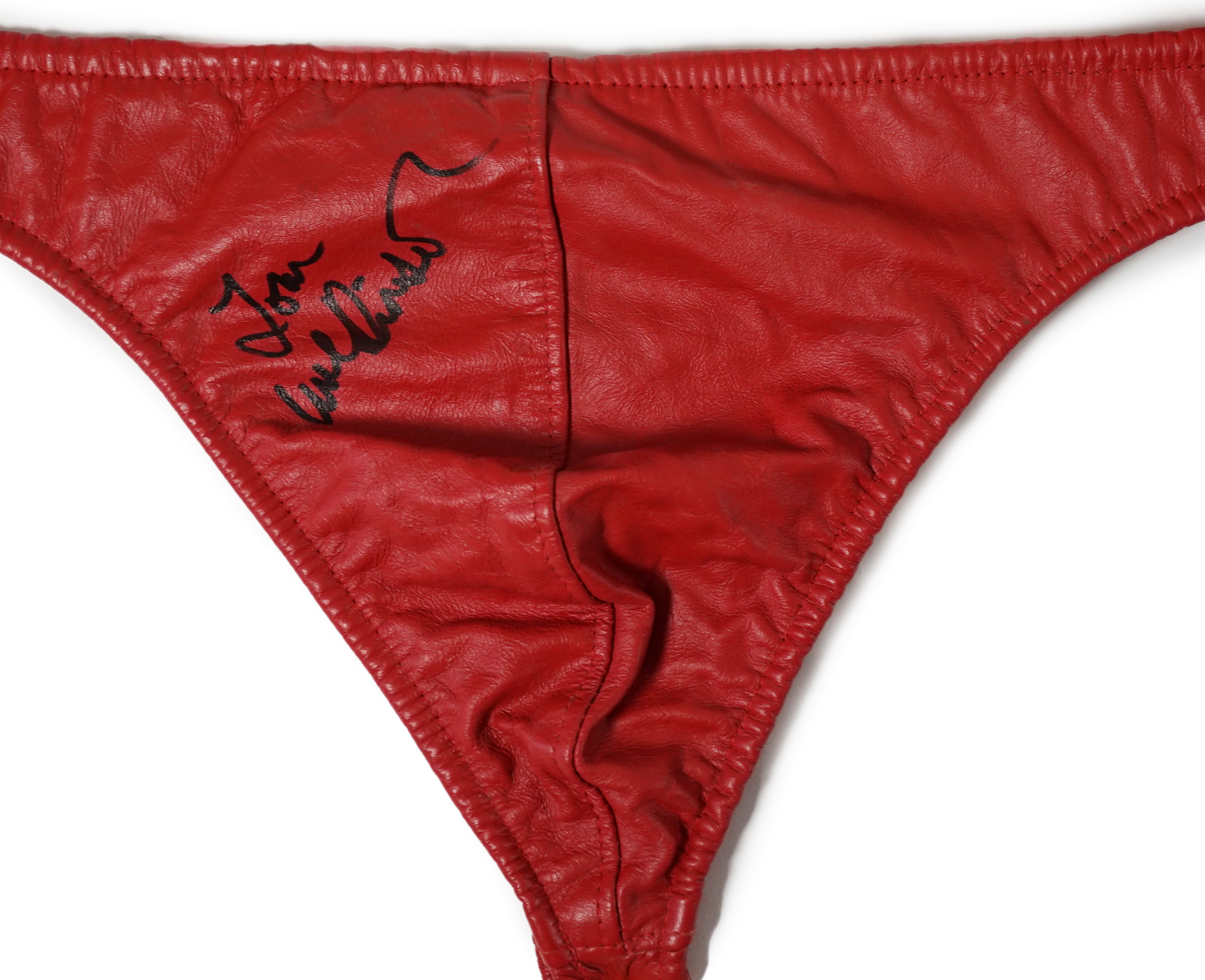 A red leather thong, as worn by Tom Wilkinson in the film The Full Monty and signed by him, together with a signed note confirming authenticity.